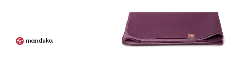 Folded purple Manduka yoga mat, ideal for staying fit while traveling, placed on a white background.