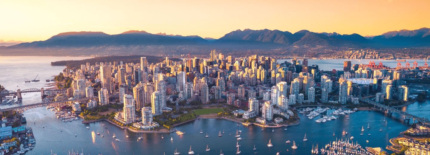 Aerial view of downtown Vancouver at sunset, an inspiring cityscape for travelers seeking fitness with mountains and water nearby.