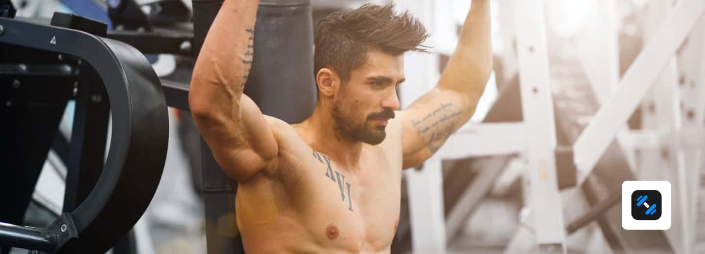 A man using a weight machine in a hotel gym, with the help of Alpha Progression, highlighting ways to stay fit while traveling.