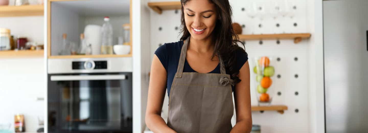 Woman prepares a healthy meal in a modern kitchen, highlighting ways to stay fit while traveling.