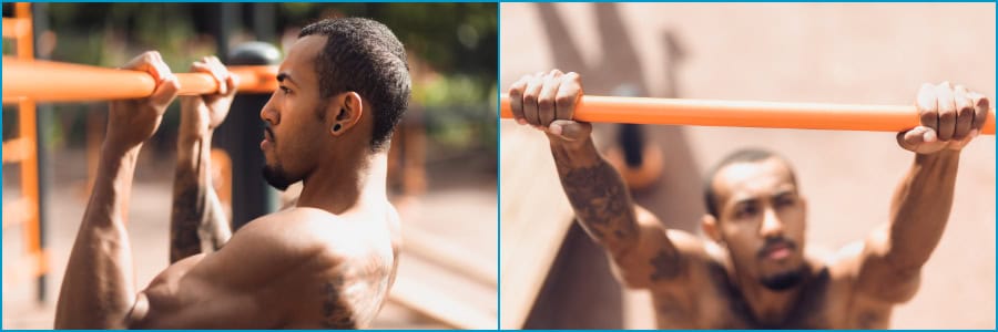 A tattooed man does pull-ups on an orange outdoor bar, viewed from the side and above, staying fit while traveling.