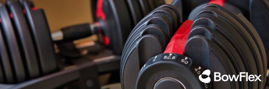 Close-up of BowFlex adjustable dumbbells and visible weight settings, ideal for hotel travelers looking to stay fit on the go.