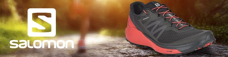 Black and red Salomon running shoe, ideal for travelers aiming to stay active.