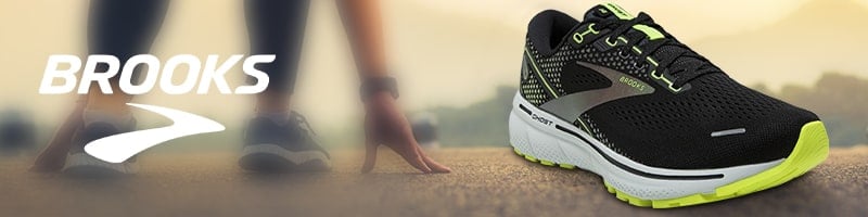 A black and neon green Brooks running shoe, perfect for staying active while traveling.