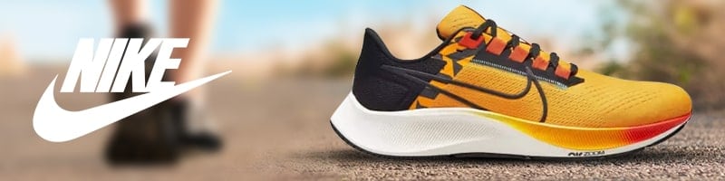 Yellow and black Nike running shoe on a path, suggesting staying active while traveling.